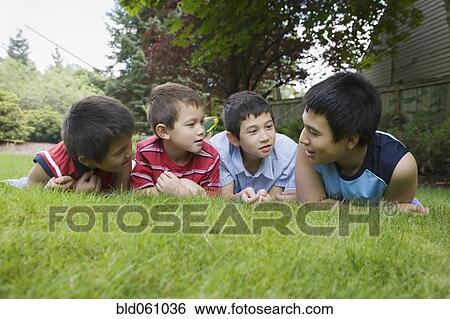 Stock Photograph - Asian brothers laying in grass. Fotosearch
