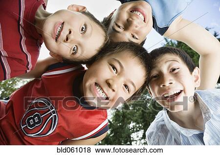 Stock Photo - Asian brothers making faces in huddle. Fotosearch