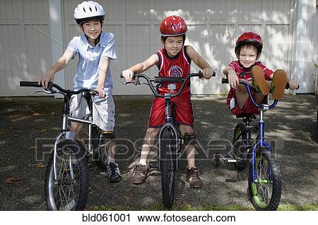 Stock Image - Asian brothers on bicycles. Fotosearch