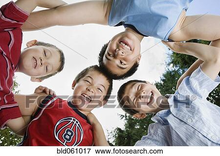 Stock Photo - Asian brothers standing in huddle. Fotosearch