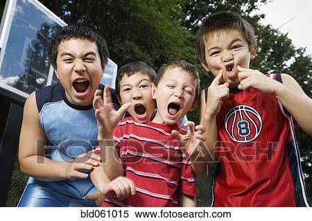 Stock Photography - Asian brothers yelling on basketball court. Fotosearch