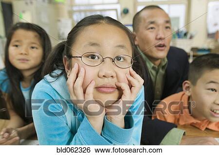 Stock Photograph - Asian children and father in classroom. Fotosearch