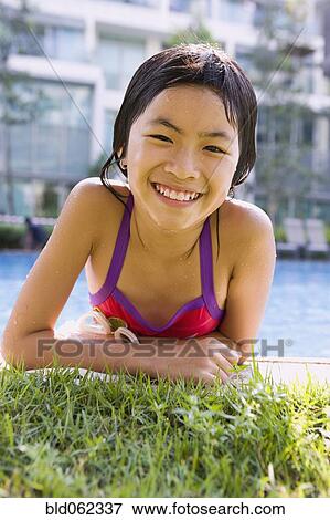 Stock Photo - Asian girl getting out of swimming pool. Fotosearch