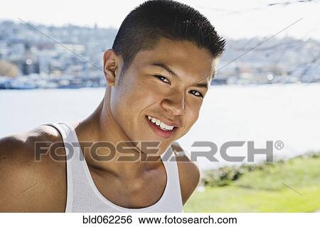 Stock Photograph - Asian man at urban waterfront. Fotosearch