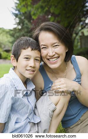 Stock Photograph - Asian mother and son hugging. Fotosearch