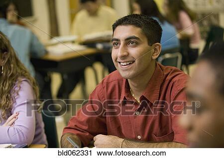 Stock Image - Asian student listening to teacher in classroom. Fotosearch