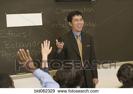 Stock Photo - Asian teacher talking to students in classroom. Fotosearch