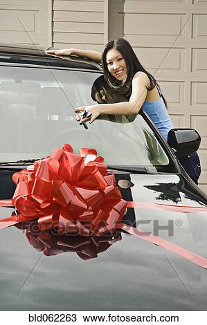 Stock Image - Asian teenager adoring new car. Fotosearch