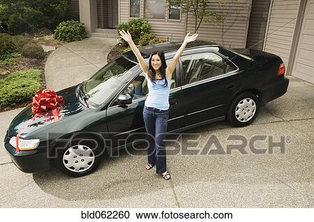 Stock Image - Asian teenager celebrating new car. Fotosearch