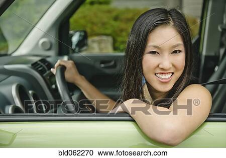 Stock Image - Asian teenager driving car. Fotosearch