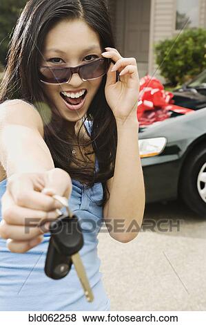 Asian teenager holding keys to new car View Large Photo Image Stock Photo - Asian teenager holding keys to new car. Fotosearch