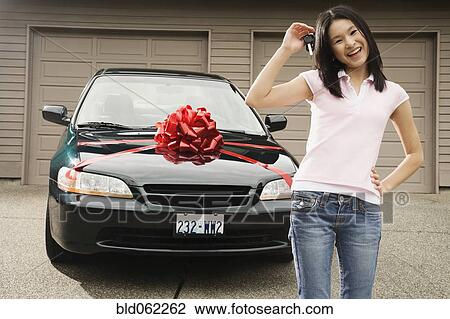 Stock Image - Asian teenager with keys to new car. Fotosearch