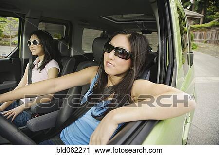 Stock Image - Asian teenagers driving in car. Fotosearch