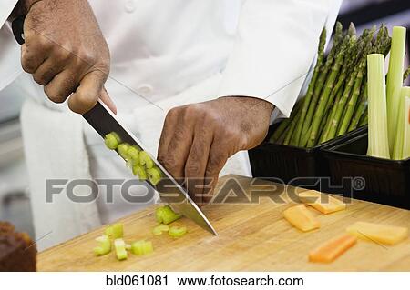 Stock Image - Close up of chef chopping vegetables. Fotosearch