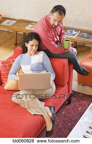 Stock Photo - Hispanic couple looking at laptop. Fotosearch