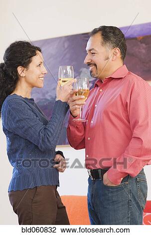 Stock Image - Hispanic couple toasting with wine. Fotosearch