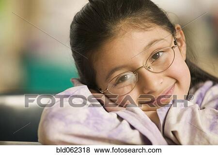 Hispanic girl laying her head on arms View Large Photo Image Stock Photo - Hispanic girl laying her head on arms. Fotosearch