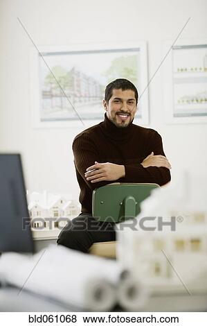 Hispanic male architect sitting in office View Large Photo Image Stock Photo - Hispanic male architect sitting in office. Fotosearch