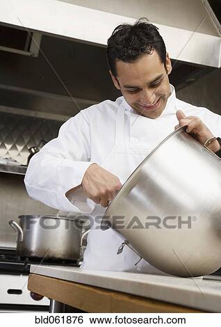 Stock Photograph - Hispanic male chef mixing batter. Fotosearch