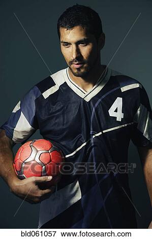 Hispanic male soccer player holding ball View Large Photo Image Stock Photo - Hispanic male soccer player holding ball. Fotosearch