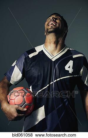 Hispanic male soccer player holding ball View Large Photo Image Stock Photo - Hispanic male soccer player holding ball. Fotosearch
