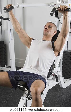 Picture - Hispanic man exercising in gym. Fotosearch