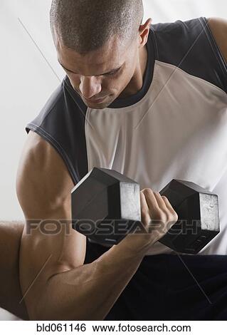 Hispanic man lifting free weights View Large Photo Image Stock Photograph - Hispanic man lifting free weights. Fotosearch