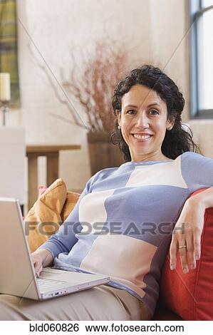 Hispanic woman holding laptop View Large Photo Image Stock Photograph - Hispanic woman holding laptop. Fotosearch