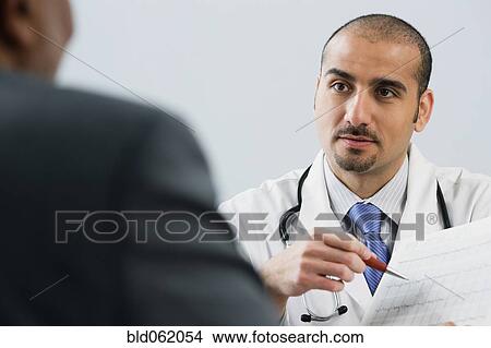 Picture - Lebanese male doctor talking with patient. Fotosearch