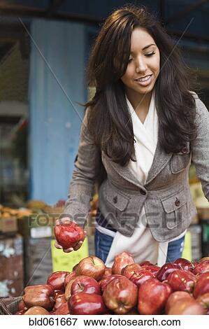Stock Photo - Middle Eastern woman shopping for apples. Fotosearch