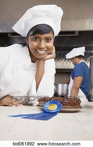 Mixed Race female pastry chef with blue ribbon and cake View Large Photo Image Stock Image - Mixed Race female pastry chef with blue ribbon and cake. Fotosearch