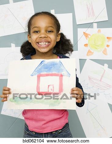 Picture - Mixed race girl holding water color painting of a house. Fotosearch