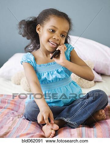 Mixed race girl in bedroom using cell phone View Large Photo Image Stock Image - Mixed race girl in bedroom using cell phone. Fotosearch