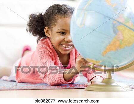 Stock Photo - Mixed race girl looking at globe. Fotosearch