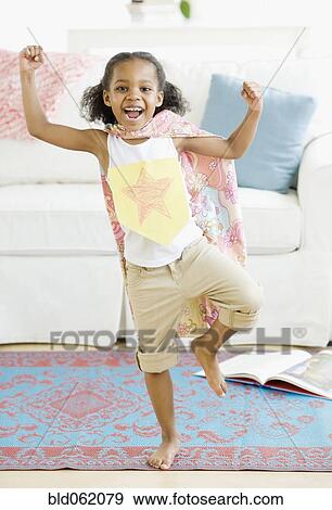 Stock Photo - Mixed race girl pretending to be superhero. Fotosearch