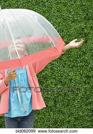 Stock Photo - Mixed race girl with umbrella in the rain. Fotosearch
