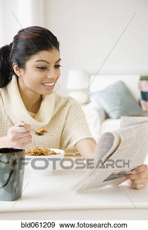 Mixed Race woman eating breakfast View Large Photo Image Stock Photo - Mixed Race woman eating breakfast. Fotosearch