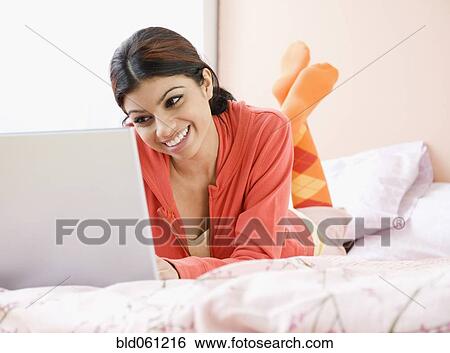Mixed Race woman looking at laptop View Large Photo Image Stock Photograph - Mixed Race woman looking at laptop. Fotosearch