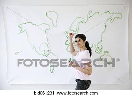 Stock Image - Mixed Race woman painting world map. Fotosearch