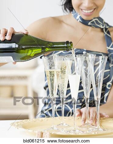 Mixed Race woman pouring champagne View Large Photo Image Stock Photography - Mixed Race woman pouring champagne. Fotosearch