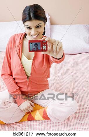 Stock Photo - Mixed Race woman taking own photograph. Fotosearch