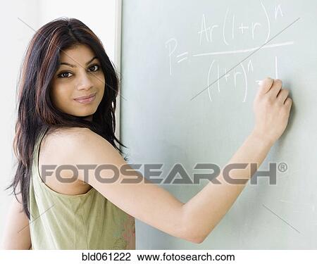 Mixed Race woman writing on blackboard View Large Photo Image Stock Image - Mixed Race woman writing on blackboard. Fotosearch