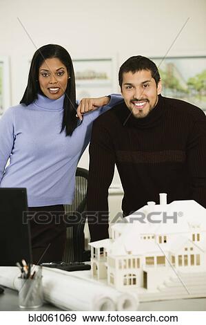Multi-ethnic architects next to house model View Large Photo Image Stock Photo - Multi-ethnic architects next to house model. Fotosearch