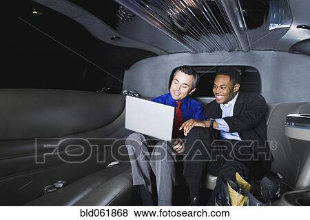 Stock Photo - Multi-ethnic businessmen looking at laptop. Fotosearch