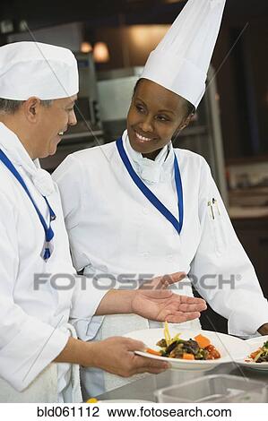 Stock Image - Multi-ethnic chefs discussing food. Fotosearch