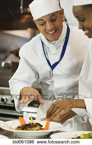 Stock Photograph - Multi-ethnic chefs discussing food. Fotosearch