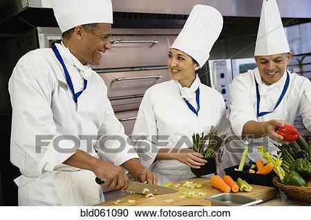 Stock Image - Multi-ethnic chefs preparing food. Fotosearch