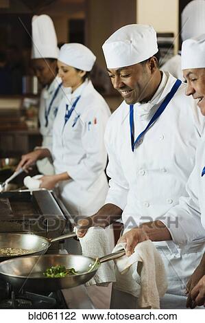 Stock Image - Multi-ethnic chefs preparing food. Fotosearch