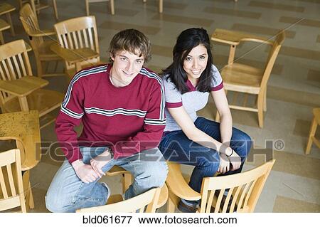 Stock Photo - Multi-ethnic college students sitting on desks. Fotosearch