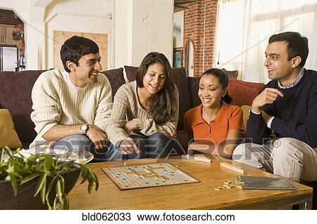 Stock Image - Multi-ethnic family playing board game. Fotosearch